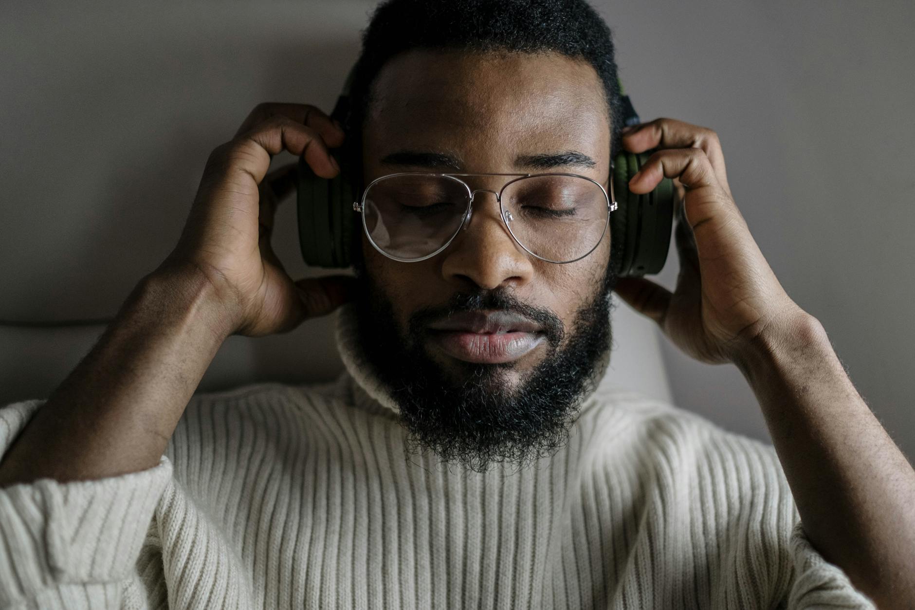 close up of a man wearing eyeglasses listening to music