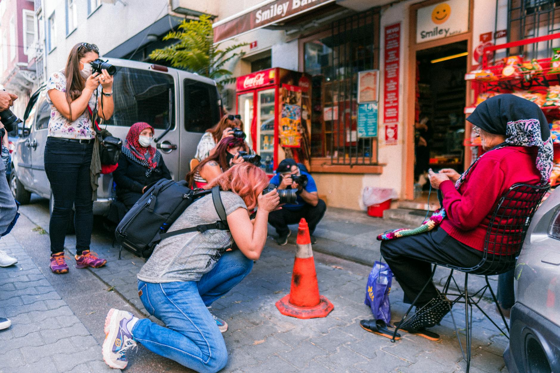 people taking picture of woman making a bag